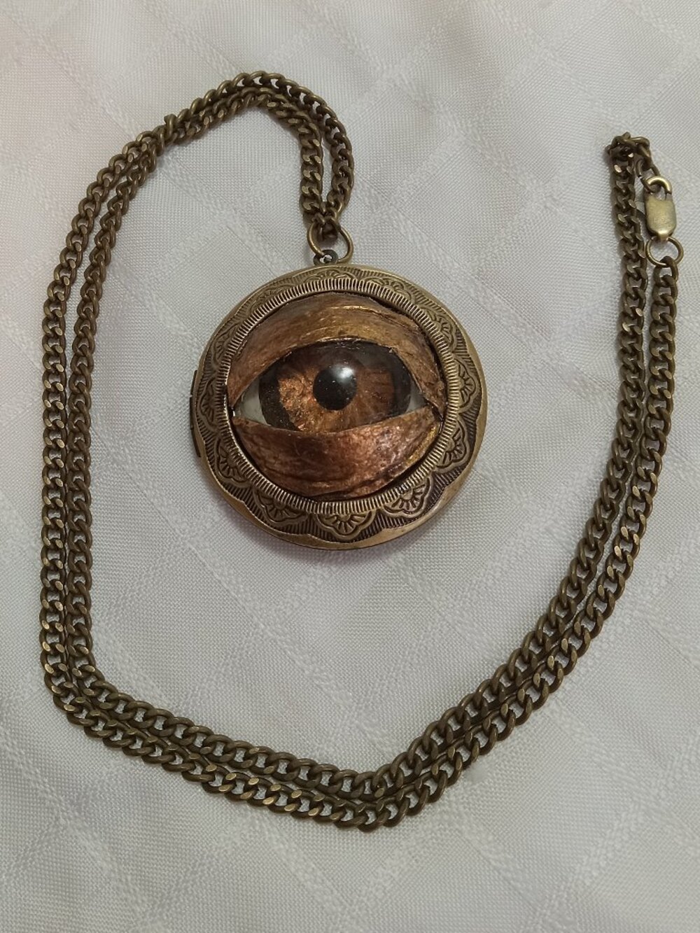 A beautiful, handcrafted eye pendant, made entirely by hand on a bronze-colored